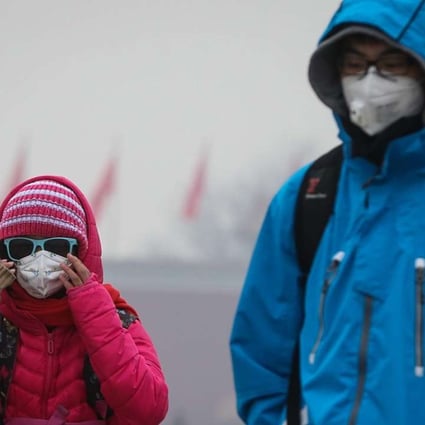 Tourists pictured wearing protective masks while visiting Tiananmen Square in Beijing last month. Photo: EPA