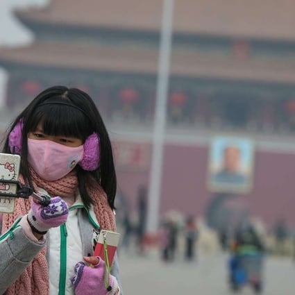 A woman pictured wearing a face mask in Tiananmen Square last month to protect against smog. Photo: EPA