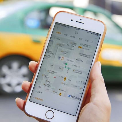 A commuter shows the Didi Chuxing app on her iPhone in Beijing. The dominant ride-hailing application has begun testing an interface in English, and has begun to accept international credit cards for the first time. Photo: EPA