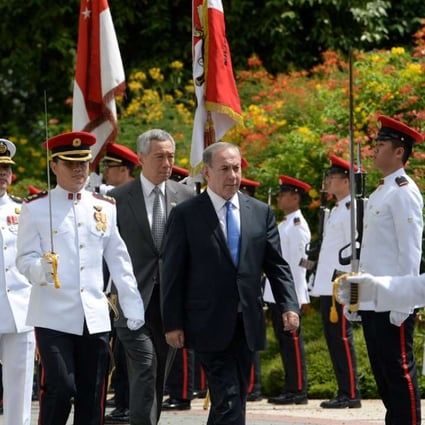 Israel’s Prime Minister Benjamin Netanyahu and his Singaporean counterpart Lee Hsien Loong inspect a guard of honour at the Istana presidential palace in Singapore. Photo: AFP