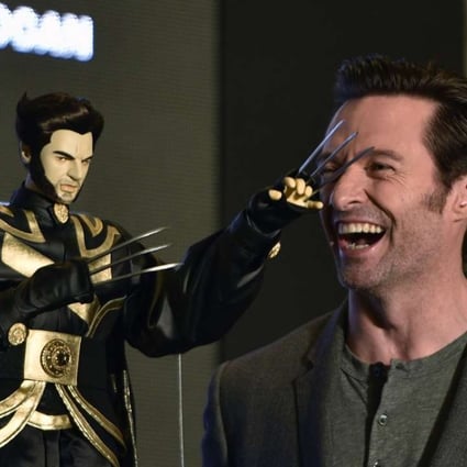 Australian actor Hugh Jackman laughs next to a Wolverine puppet gift while promoting Logan in Taipei this week. Photo; AFP