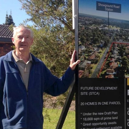 Sydney resident Ron Buxton poses with his home's for-sale sign in the suburb of Castle Hill, Sydney, Australia. Photo: Reuters