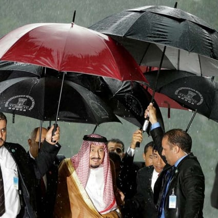 Saudi King Salman is sheltered from the rain upon his arrival at the presidential palace in Bogor, West Java. Photo: AFP