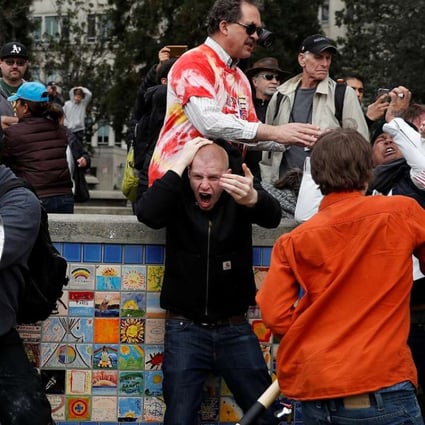 A demonstrator supporting US President Donald Trump (L) holds a shield as a group of men punch a counter demonstrator during a ‘People 4 Trump’ rally in Berkeley, California. Photo: Reuters