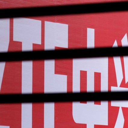 The company logo of ZTE is seen through a wooden fence on a glass door during the company's 15th anniversary celebration in Beijing in 2013. The company has agreed to pay a record fine to the US for violating sanctions against Iran and North Korea. Photo: Reuters