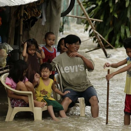 Villagers sit amid floodwaters in the typhoon-hit town of La Paz, Tarlac province, in southern Manila on December 17, 2015. The frequency of extreme weather will increase in line with global temperatures. Photo: EPA