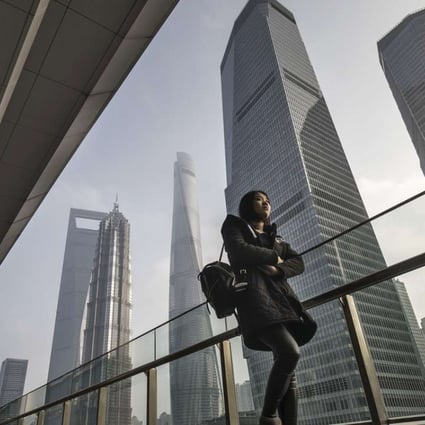 A woman walks down a corridor as skyscrapers of the Pudong area stand in Shanghai, China, on Wednesday, Jan. 4, 2017. After defying skeptics with solid economic growth last year, China aims to do the same again in 2017. Photographer: Bloomberg