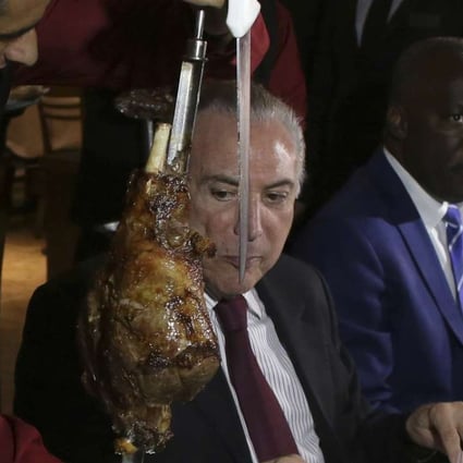Brazil’s President Michel Temer (centre) enjoying a steak dinner at a traditional Brazilian barbecue restaurant on Sunday. Photo: AP