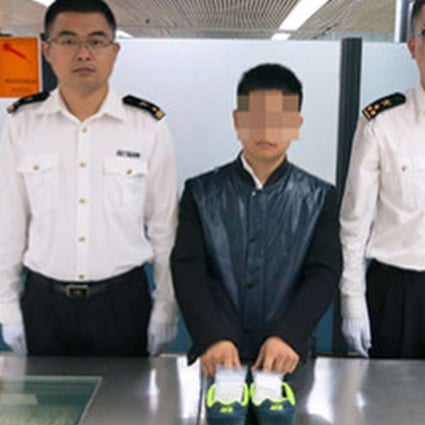 Shenzhen customers officials with the apprehended diamond smuggler. Photo: Lo Wu Customs