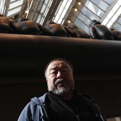 Chinese activist and artist Ai Weiwei poses by his installation displayed at the National Gallery in Prague, Czech Republic featuring a 70-metre-long inflatable boat with life-size figures of 258 refugees prepared for the gallery. Photo: AP