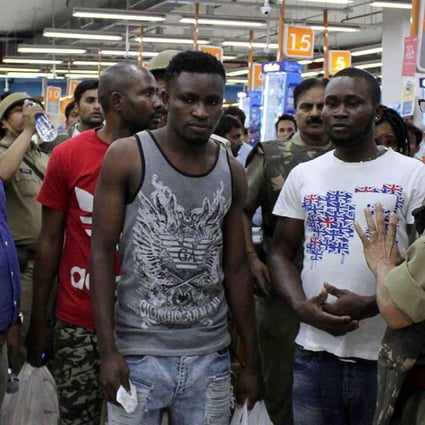 Indian police and onlookers surround African nationals at a shopping mall in Greater Noida on March 27. Hundreds of residents of an Indian city where a teenage boy died of a suspected drug overdose went on a violent rampage against Africans, using steel chairs to attack shoppers in a local mall. The riots broke out after New Delhi released five African students detained over the death. Photo: AFP