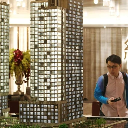 A potential buyer views a model of Cheung Kong Property’s Harbour Glory development. Photo: K. Y. Cheng