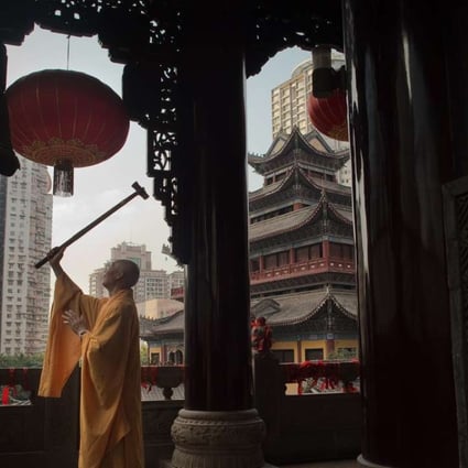 A Buddhist monk rings a bell with a wooden hammer at the Arhat temple in Chongqing. Picture: AFP