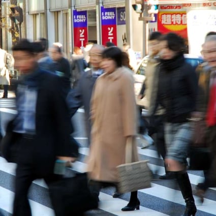 Commuters cross an intersection in downtown Tokyo. Photo: AP