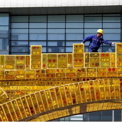 A worker walks along a “Silk Road Golden Bridge”, on display outside the National Convention Centre in Beijing, the venue which will hold the Belt and Road Forum for International Cooperation in May. India’s apprehension that the belt and road will merely serve China’s interest shows that New Delhi underestimates the transformative potential of the project. Photo: AP