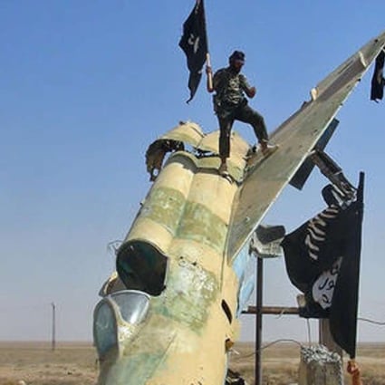 A file picture of Islamic State fighters next to a destroyed Syrian air force jet. Photo: Associated Press