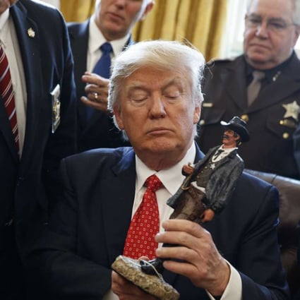 US President Donald Trump receives a figurine from a group of county sheriffs. Photo: AP