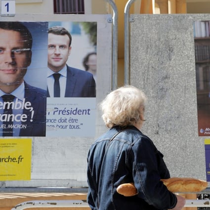 A woman walks past new official posters for the candidates in the 2017 French presidential election, Emmanuel Macron (L), head of the political movement En Marche !, or Onwards !, and Marine Le Pen (R) of French National Front (FN) political party, in Nice, France, on May 2, 2017. Photo: Reuters