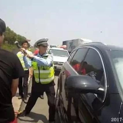 A police officer smashes his way into the car. Photo: Handout
