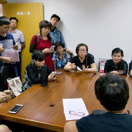 An official from the Beijing Municipal Commission of Housing and Urban-rural Development talks with protesting apartment buyers on Wednesday. Photo: Tom Wang