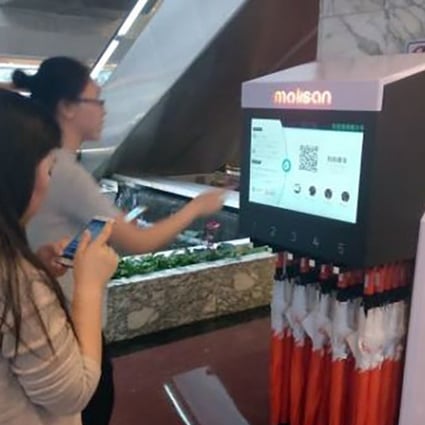 Commuters check out Molisan’s rented umbrellas at a Chinese subway station. Photo: Handout