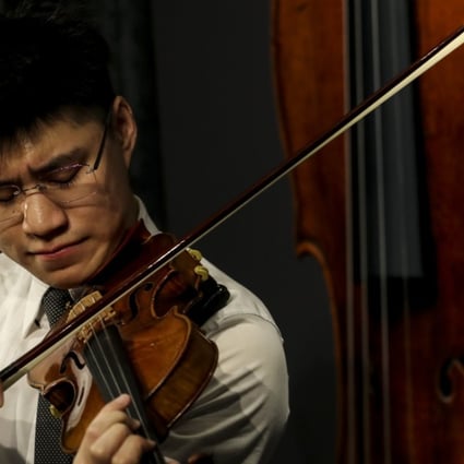 Vince Eliezer N. Chua, a master's degree student majoring in violin at The Hong Kong Academy for a Performing Arts (HKAPA), plays a rare 1684 violin known as the Ex-Croall; McEwen by Antonio Stradivari, estimated at HK$12-19 million, at Sotheby's Hong Kong office in Admiralty. Photo: Nora Tam