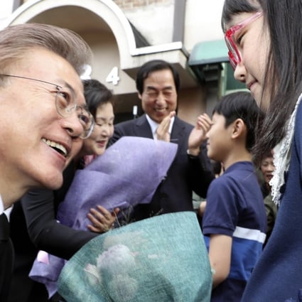 Moon Jae-in is greeted by a young supporter as he leaves his private residence for the presidential Blue House in Seoul on May 10. Photo: EPA