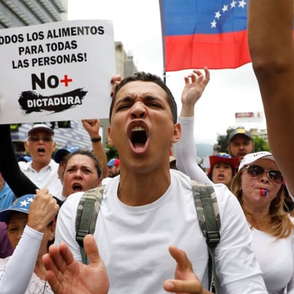 Demonstrators hold a sign reads: ' All the food for all the people! No more dictatorship ' while rallying against Venezuela's President Nicolas Maduro in Caracas, Venezuela, on May 1. Photo: Reuters
