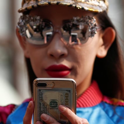 A woman uses a mobile phone during China Fashion Week in Beijing. Photo: Reuters