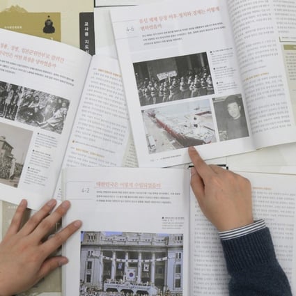 A government worker shows the final version of state-authored history textbooks President Moon is scrapping. Photo: AP
