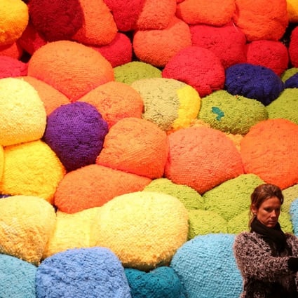 A visitor takes a selfie in front of Escalade Beyond Chromatic Lands, an installation by American artist Sheila Hicks, during the 57th Venice Biennale. Photo: Reuters