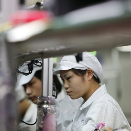 Employees on the assembly line of Hon Hai Group, also called Foxconn, in Shenzhen. The company is the world’s largest electronics contract manufacturer, producing Apple’s iPhones and iPads. Photo: SCMP