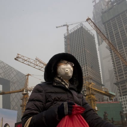 A woman wears a mask as smog continues to choke Beijing in this January file photo. Photo: AP