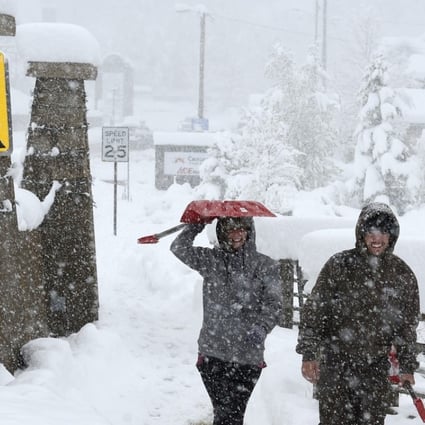 Emily Weir, left, and Barrac Elgee, head to their home for snow shovelling during a steady snow in Nederland, Colorado. A rare May snow dump up to three feet of snow across Colorado. Photo: AP