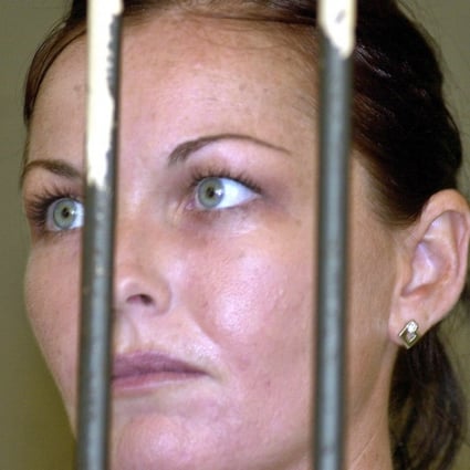 Convicted drug smuggler Schapelle Corby stands behind the bars at court's prison. Photo: AP