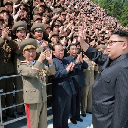 North Korean leader Kim Jong-un waves to scientists and technicians who helped develop his missile programme. Photo: Reuters