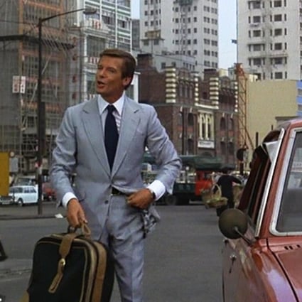 Roger Moore as 007 in a Hong Kong Island street scene in Man with the Golden Gun. Western Market in Sheung Wan is in the background.