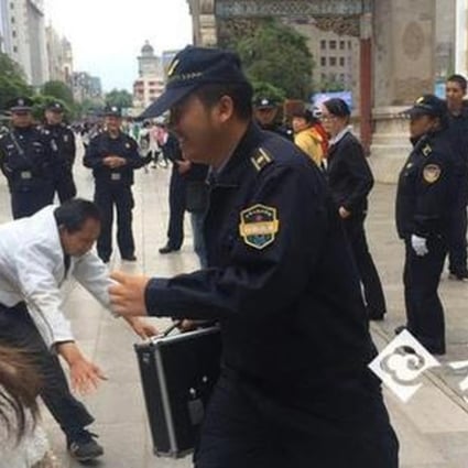 An urban enforcement official in Kunming laughs as a masseur tries to find a loudspeaker telling the public not to use his service. Photo: Yunnan.cn