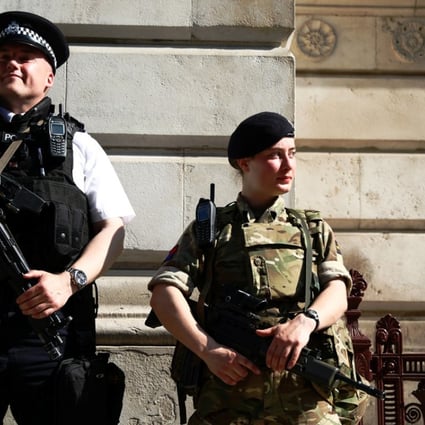 A soldier and a police officer stand guard at Downing Street in London. Photo: Reuters