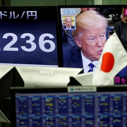 US President Donald Trump and Japanese Prime Minister Shinzo Abe seen on a TV monitor as the one next to it shows the yen’s exchange rate against the US dollar, at a forex trading company in Tokyo on February 1. Photo: Reuters