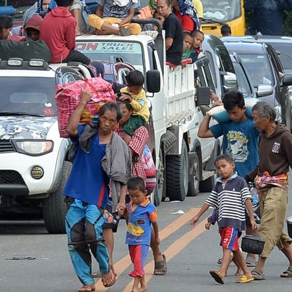 Families carrying their belongings flee Marawi city, in the southern mainly Muslim island of Mindanao, on May 26, amid fighting between Islamist militants and government forces. Photo: AFP