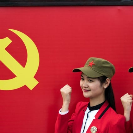 Chinese tourists posing in front a flag of the Communist Party of China in Shaoshan in Hunan province. Shaoshan is the hometown of Mao Zedong. The small village is a hot spot for 'red tourism'. Millions of Mao devotees from all over the country come to Shaoshan every year. Photo: AFP