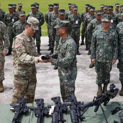 Philippine Marine Major General Emmanuel Salamat, fourth from right, receives an M4 rifle with grenade launcher from US Army Colonel Ernest Lee during turnover of brand new military weapons. Photo: AP