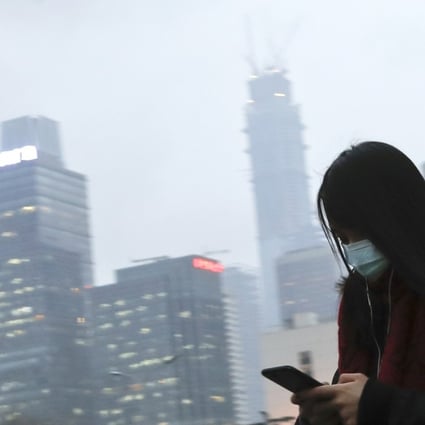 A file picture of a woman checking her phone during heavy smog in Beijing in February this year. Photo: Associated Press