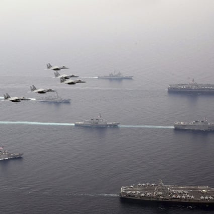Japan Air Self-Defence Force's F-15 fighter jets fly over US Navy aircraft carriers, USS Ronald Reagan, right bottom, and USS Carl Vinson, right top, Japan Maritime Self Defence Force JS Hyuga, right centre, and other vessels during Japan-US joint training in the Sea of Japan (East Sea) Photo: Kyodo