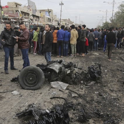 Citizens inspect the scene after a car bomb explosion at a crowded outdoor market in Sadr City, Iraq, on Jan 2. A suicide bomber blew up his explosives-laden vehicle, killing at least a dozen people, amid a fierce regional fight against the Islamic State group. Photo: AP