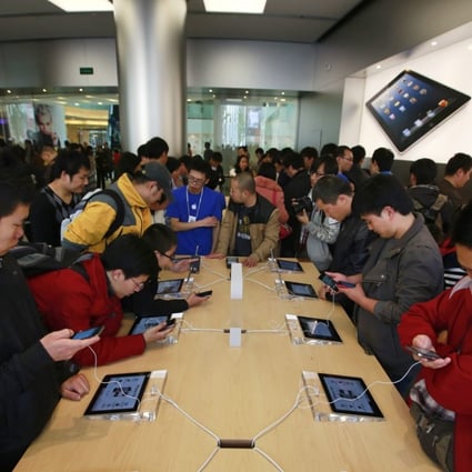 Chinese customers look at Apple products in Apple’s Wangfujing shopping district store in Beijing. Chinese authorities say they have uncovered a massive underground operation run by Apple employees selling computer and phone users’ personal data. Photo: EPA