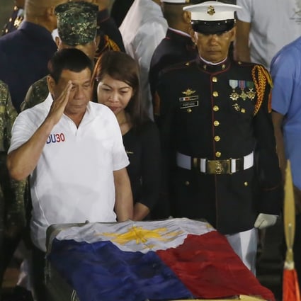 Philippine President Rodrigo Duterte salutes at the flag-draped casket of a marine killed in fighting in Marawi. Photo: AP