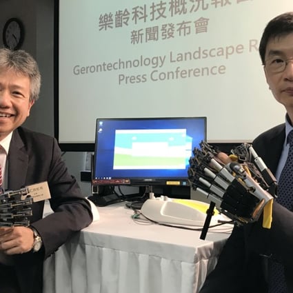 (From left) Professor Stephen Cheung Yan-leung, chairman of the Social Innovation and Entrepreneurship Development Fund Task Force, and Chua Hoi-wai, chief executive of the Hong Kong Council of Social Service, show off technological devices designed for the elderly. Photo: Elizabeth Cheung