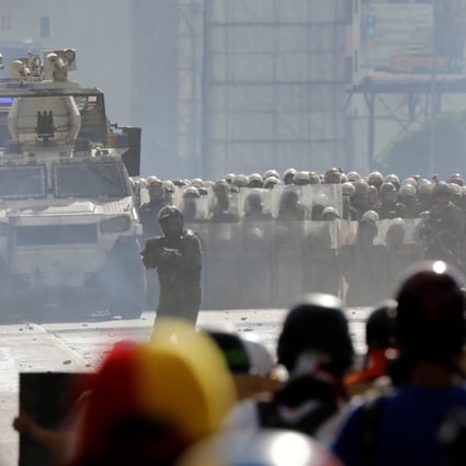 Demonstrators clash with riot security forces in Caracas. A VN-4 armoured personnel carrier, made by China’s defence conglomerate China North Industries Group Corp, or Norinco is in the foreground. Photo: Reuters